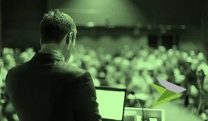 Speaker at conference, in a green tone