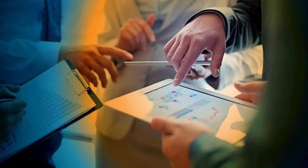 Three people pointing at tablet screen