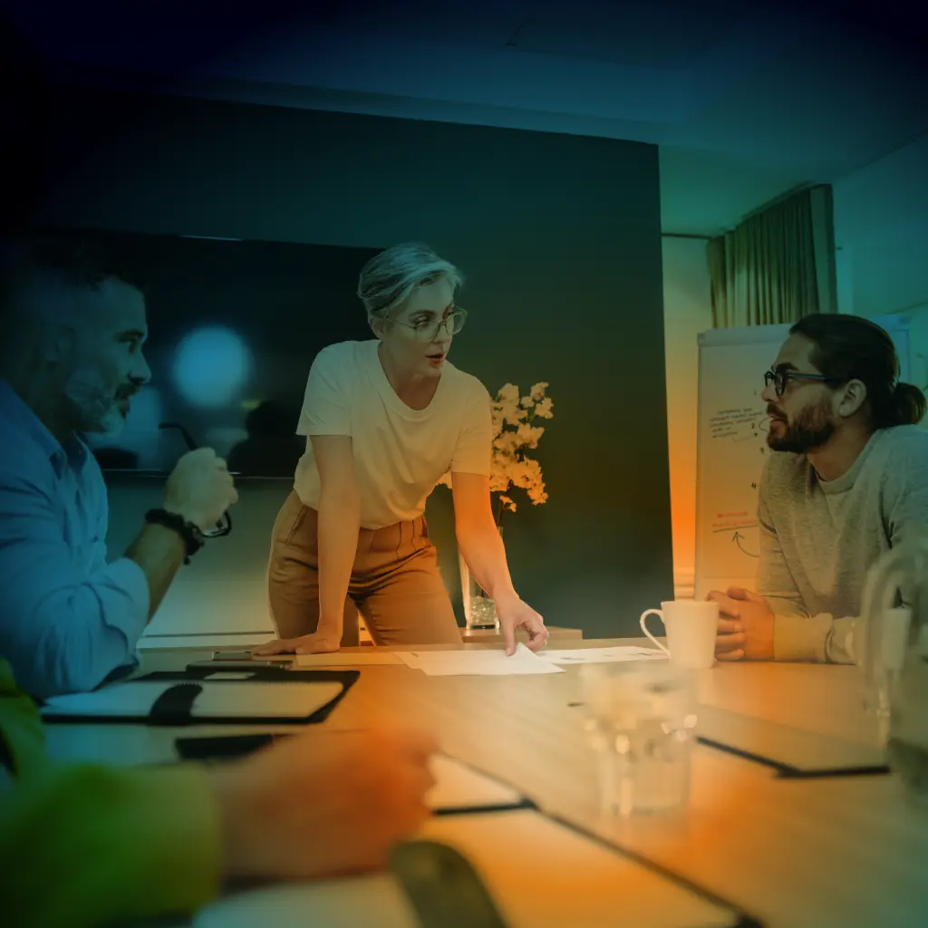 Three people talking around a conference room table