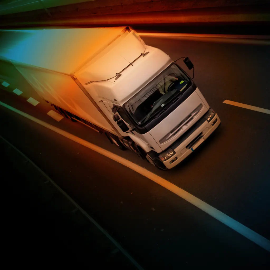 A white truck driving towards the camera at an angle