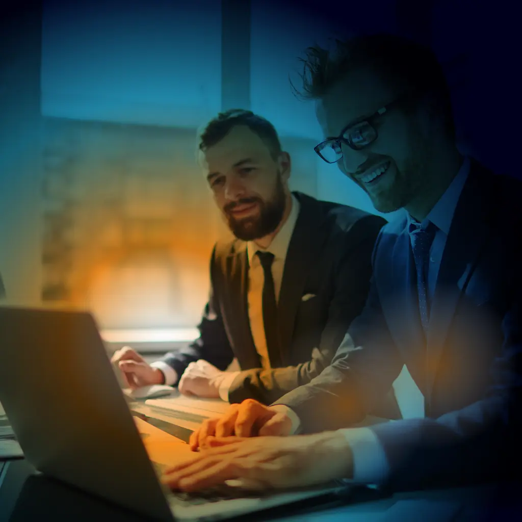 Two people looking at a laptop screen