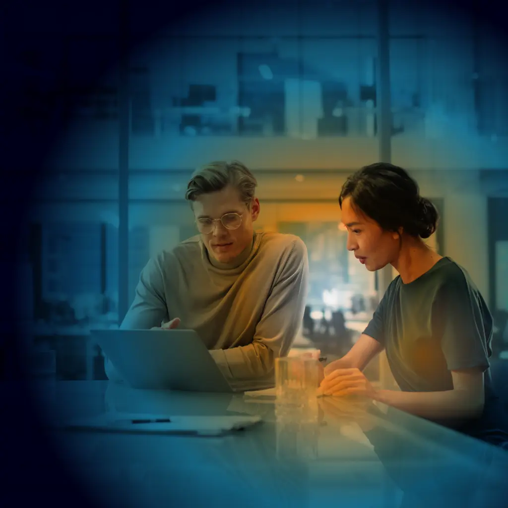 Two people with a laptop in a conference room