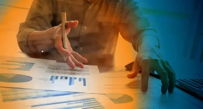 Hands reviewing bar charts on a desk