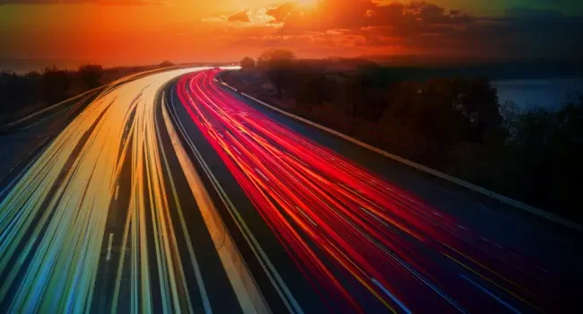 Motorway at sunset with vehicle headlights blurred