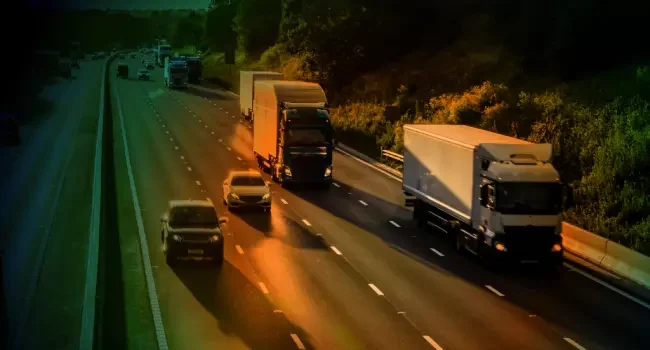Busy motorway with two trucks and several cars